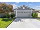 Charming home featuring a gray two-car garage, nicely landscaped yard, and a concrete driveway at 31820 Blythewood Way, Wesley Chapel, FL 33543