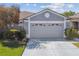 Home featuring a two-car garage with an expansive driveway, complemented by lush landscaping and manicured lawn at 31820 Blythewood Way, Wesley Chapel, FL 33543