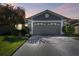 Home featuring a two-car garage with an expansive driveway, complemented by lush landscaping and manicured lawn at 31820 Blythewood Way, Wesley Chapel, FL 33543