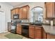 A kitchen with wood cabinets, tiled backsplash, and black appliances at 31820 Blythewood Way, Wesley Chapel, FL 33543