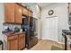 Kitchen area featuring black appliances, ample wood cabinetry and tile flooring at 31820 Blythewood Way, Wesley Chapel, FL 33543