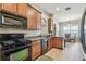 Bright kitchen featuring black appliances, tile flooring, and wood cabinets at 31820 Blythewood Way, Wesley Chapel, FL 33543
