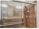 A tiled walk-in shower featuring glass doors and a storage caddy at 31820 Blythewood Way, Wesley Chapel, FL 33543