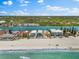 An aerial view features beachfront houses alongside a road, with docks, a beautiful beach, and clear blue water at 32 Gulf Blvd, Indian Rocks Beach, FL 33785