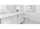 Modern bathroom with white vanity, unique mirror, and patterned floor tiles for a clean and stylish design at 32 Gulf Blvd, Indian Rocks Beach, FL 33785