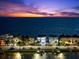 An illuminated beachfront home with three stories provides easy access to docks and stunning sunset views at 32 Gulf Blvd, Indian Rocks Beach, FL 33785