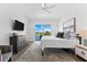 Bedroom features wood floors, ceiling fan, and scenic view, creating a serene and modern living space at 32 Gulf Blvd, Indian Rocks Beach, FL 33785