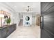 Bright foyer with tiled floors, a decorative console, and a modern chandelier leads to the staircase at 32 Gulf Blvd, Indian Rocks Beach, FL 33785