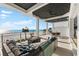 A covered patio features stylish furniture, a fire pit and beautiful beach views in this stunning home at 32 Gulf Blvd, Indian Rocks Beach, FL 33785