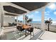 A covered patio features stylish furniture, a ceiling fan and beautiful beach views in this stunning home at 32 Gulf Blvd, Indian Rocks Beach, FL 33785