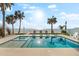 Beautiful beachside pool with lounge chairs and palm trees, perfect for relaxing at 32 Gulf Blvd, Indian Rocks Beach, FL 33785