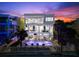 Rear exterior view of a luxury home featuring a private pool, multiple balconies, and lush palm trees at 32 Gulf Blvd, Indian Rocks Beach, FL 33785