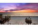 A beautiful sunset view from the beach shows the ocean and silhouetted palm trees at 32 Gulf Blvd, Indian Rocks Beach, FL 33785