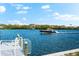 A waterfront view features a boat on the water, a private dock with white railings, and blue skies at 32 Gulf Blvd, Indian Rocks Beach, FL 33785