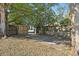 Backyard featuring mature trees and a gated wooden fence enclosing the concrete driveway at 3220 10Th N St, St Petersburg, FL 33704