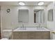 Bathroom with double sink vanity featuring stylish mirrors, ample lighting and modern fixtures at 3220 10Th N St, St Petersburg, FL 33704