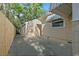 Exterior showcasing a tan house, detached garage, and long driveway enclosed by a wooden fence at 3220 10Th N St, St Petersburg, FL 33704