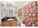 Bathroom with a wooden cabinet sink, large mirror, toilet and shower with flowered curtain at 3310 Haviland Ct # 202, Palm Harbor, FL 34684
