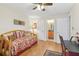 Bright bedroom features hardwood floors, a daybed, and an open doorway to a bathroom at 3310 Haviland Ct # 202, Palm Harbor, FL 34684