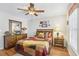 Comfortable bedroom featuring a ceiling fan, hardwood floors, and a large window at 3310 Haviland Ct # 202, Palm Harbor, FL 34684