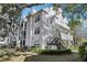 Exterior view of a two-story apartment building with white siding and black stairs at 3310 Haviland Ct # 202, Palm Harbor, FL 34684
