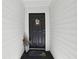 Black front door of a condo with seasonal decor and a welcome mat on the porch at 3310 Haviland Ct # 202, Palm Harbor, FL 34684