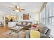 Open living room that flows into kitchen featuring a ceiling fan, sofas and a glass coffee table at 3310 Haviland Ct # 202, Palm Harbor, FL 34684