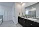 Bathroom with double vanity, granite counters, a large mirror, and shower enclosure at 33298 Major Oak Dr, Wesley Chapel, FL 33545