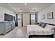 This bedroom features a decorative tray ceiling, light wood floors and neutral decor at 33298 Major Oak Dr, Wesley Chapel, FL 33545