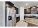 Stainless steel refrigerator and dark cabinets complement the granite countertops in the kitchen at 33298 Major Oak Dr, Wesley Chapel, FL 33545