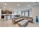 Bright living room with a comfortable sectional sofa and access to a modern kitchen and dining area at 33298 Major Oak Dr, Wesley Chapel, FL 33545