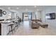 Open floorplan with a kitchen island, dining area, and living room with sliding glass doors to a covered patio at 33298 Major Oak Dr, Wesley Chapel, FL 33545