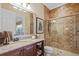 Bathroom with granite countertop vanity, framed mirror, tiled shower with glass doors, and a toilet at 3543 Watermark Dr, Wesley Chapel, FL 33544