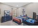 Bright bedroom with blue furnishings, a window for natural light, a desk area, carpeted floors, and gaming-themed decor at 3543 Watermark Dr, Wesley Chapel, FL 33544