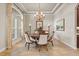 Formal dining room with a grand chandelier, large windows, and comfortable seating for six at 3543 Watermark Dr, Wesley Chapel, FL 33544