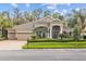Inviting home exterior featuring a three-car garage and meticulously maintained front yard at 3543 Watermark Dr, Wesley Chapel, FL 33544