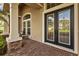 Inviting front porch with decorative glass double doors framed by stately columns and stone accents at 3543 Watermark Dr, Wesley Chapel, FL 33544