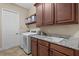 Convenient laundry room with modern appliances, granite countertops, and ample cabinet space at 3543 Watermark Dr, Wesley Chapel, FL 33544