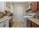 Bright laundry room featuring front loading washer/dryer, granite countertop, ample cabinet space and a built-in desk area at 3543 Watermark Dr, Wesley Chapel, FL 33544