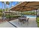 Charming covered lounge area with tables and chairs, perfect for relaxing by the pool at 3543 Watermark Dr, Wesley Chapel, FL 33544