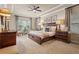 A stylish bedroom featuring a ceiling fan, carpet and elegant furnishings at 3543 Watermark Dr, Wesley Chapel, FL 33544