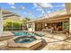 Screened-in pool with a spa, brick patio, outdoor seating, and view of the home and manicured yard at 3543 Watermark Dr, Wesley Chapel, FL 33544