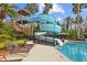 Fun water slide at the community pool surrounded by palm trees and comfortable lounge seating at 3543 Watermark Dr, Wesley Chapel, FL 33544