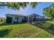 A well-maintained lawn leads to a screened-in pool and patio area in the backyard at 3720 Gaviota Dr, Ruskin, FL 33573