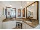 Bright bathroom features granite countertops, dual sinks, large mirrors, and stylish light fixtures at 3720 Gaviota Dr, Ruskin, FL 33573