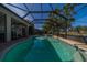 Inviting screened-in pool featuring a built-in spa, poolside seating, and views of the lush golf course at 3720 Gaviota Dr, Ruskin, FL 33573