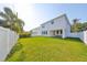 A spacious backyard features green grass, a white fence, and a two-story white home at 3915 W Euclid Ave, Tampa, FL 33629