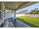 Covered patio with comfortable seating and a view of the lush backyard and fenced yard at 3915 W Euclid Ave, Tampa, FL 33629