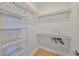 Bright walk-in closet featuring custom shelving and ample storage space with light hardwood floors at 3915 W Euclid Ave, Tampa, FL 33629