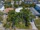 Aerial view shows a home surrounded by mature trees with a long driveway and parking area at 409 Erie Ave, Tampa, FL 33606